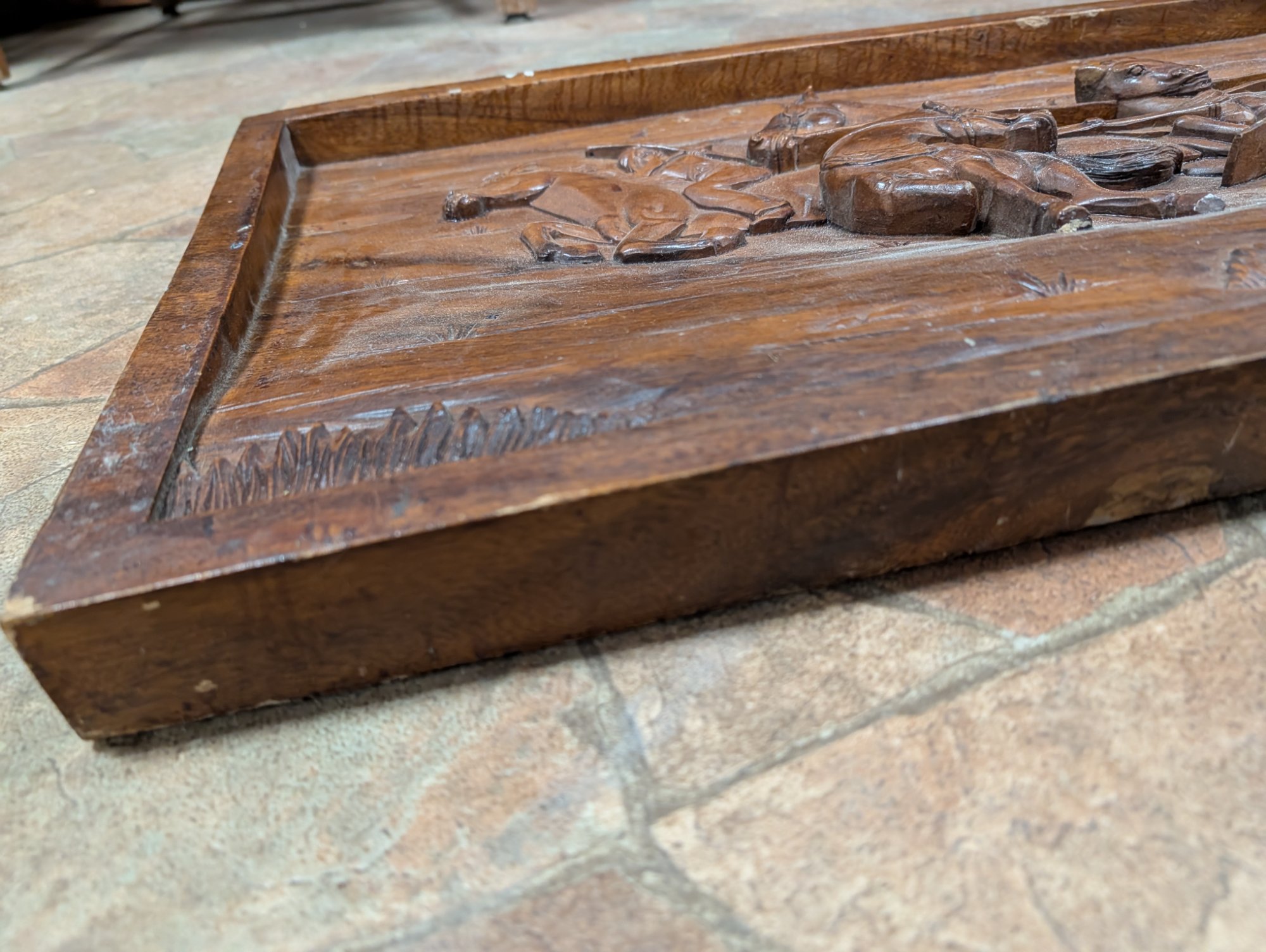 Corner detail showing carved grass, horse hooves, and the quality of the relief work