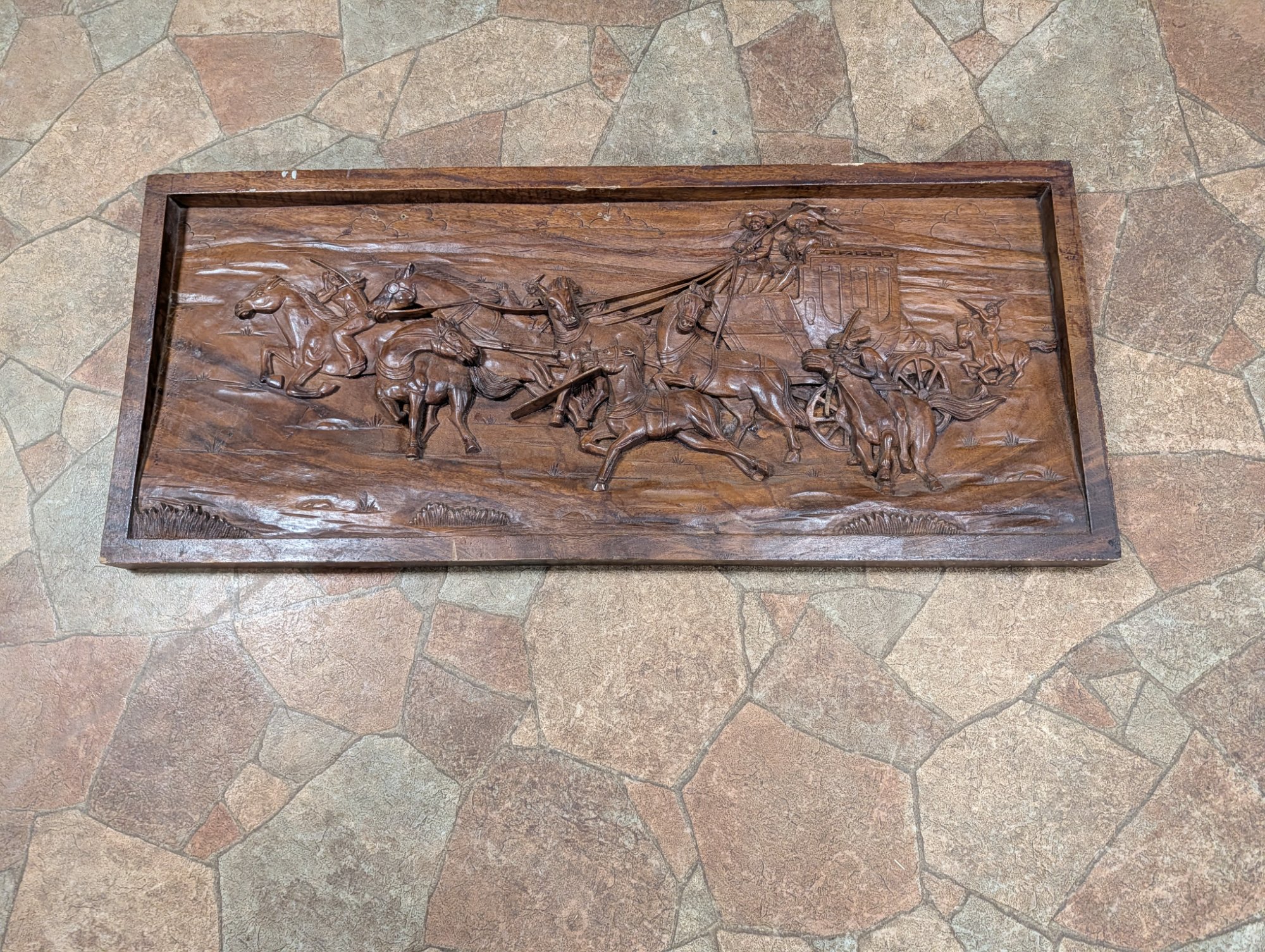 The Stagecoach Chase — hand-carved wood relief panel depicting a stagecoach robbery at full gallop